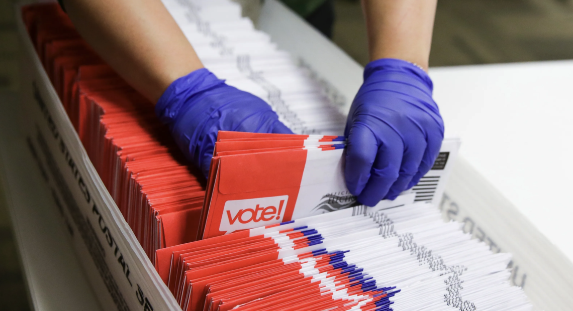 Persona depositando un sobre en un buzón de correo oficial de Estados Unidos con una papeleta electoral adentro, mientras al fondo se ve el edificio de la Corte Federal en Washington D.C., simbolizando el debate legal sobre el voto por correo.