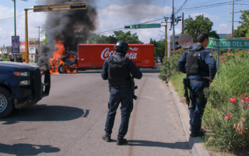 Agentes de la Guardia Nacional Mexicana con equipo táctico frente a un operativo en una calle de Nogales, Sonora, con la valla fronteriza entre México y Arizona visible al fondo, simbolizando la captura del sobrino de El Chapo y la cooperación binacional contra el narcotráfico.