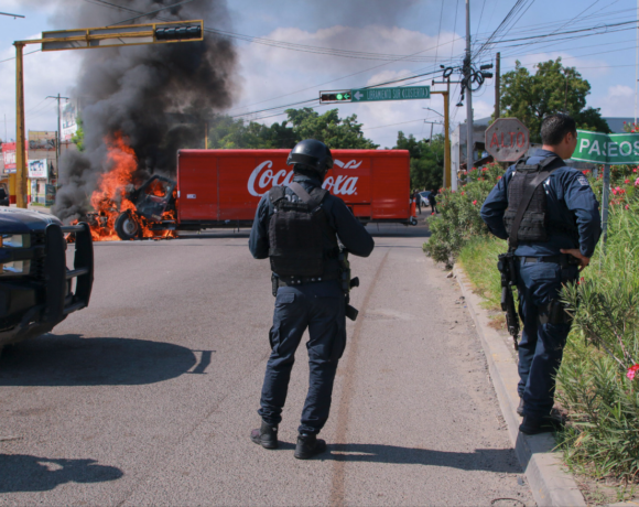 Agentes de la Guardia Nacional Mexicana con equipo táctico frente a un operativo en una calle de Nogales, Sonora, con la valla fronteriza entre México y Arizona visible al fondo, simbolizando la captura del sobrino de El Chapo y la cooperación binacional contra el narcotráfico.