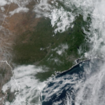 Vista del horizonte de Houston bajo un cielo parcialmente nublado y soleado con una capa de neblina visible en el ambiente, representando un Día de Acción por Ozono con calidad del aire poco saludable y altas temperaturas veraniegas en la ciudad.