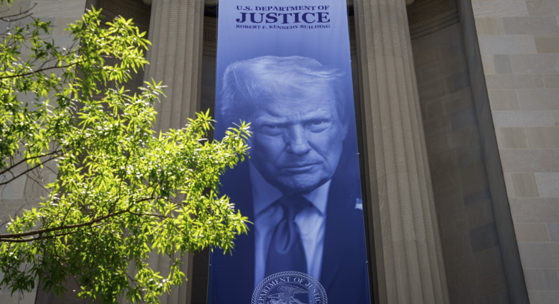 Vista exterior del edificio del Departamento de Justicia de los Estados Unidos en Washington D.C., con la bandera americana ondeando, representando la sede de la polémica decisión de crear el Fondo Anti-Weaponización de $1,800 millones actualmente bloqueado por un tribunal federal.