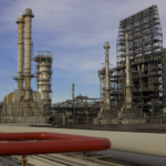 Instalaciones petroleras en la Faja del Orinoco en Venezuela, con torres de extracción de petróleo pesado bajo un cielo nublado, representando las vastas reservas de crudo venezolano que ExxonMobil negocia explotar nuevamente casi 20 años después de su expulsión durante la era de Hugo Chávez.