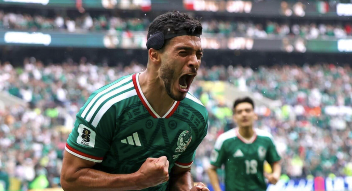 Julián Quiñones con el uniforme verde de la selección mexicana celebra el primer gol del Mundial 2026 ante una multitud eufórica en el Estadio Azteca de la Ciudad de México, con sus compañeros corriendo hacia él en señal de festejo.