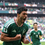 Julián Quiñones con el uniforme verde de la selección mexicana celebra el primer gol del Mundial 2026 ante una multitud eufórica en el Estadio Azteca de la Ciudad de México, con sus compañeros corriendo hacia él en señal de festejo.