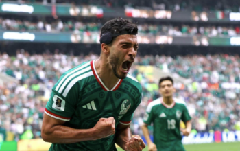 Julián Quiñones con el uniforme verde de la selección mexicana celebra el primer gol del Mundial 2026 ante una multitud eufórica en el Estadio Azteca de la Ciudad de México, con sus compañeros corriendo hacia él en señal de festejo.